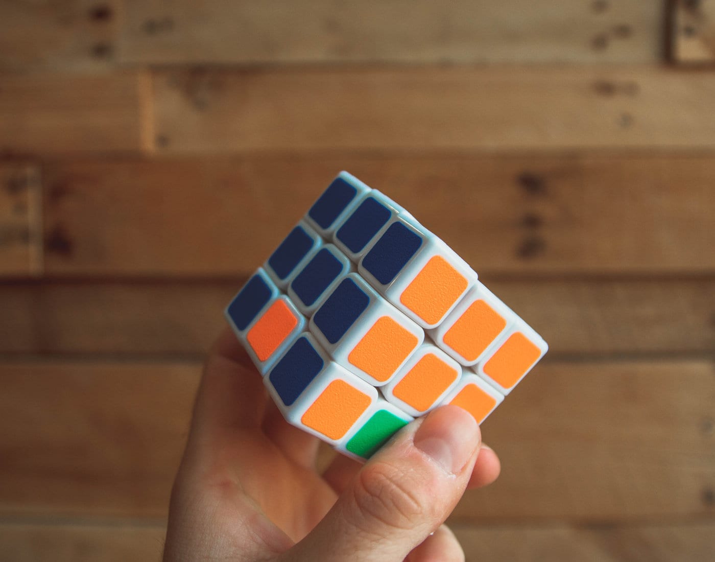 A hand turning a colorful puzzle cube